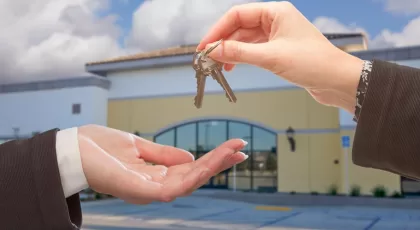 Agent Handing Over the Keys in Front of Business establishment