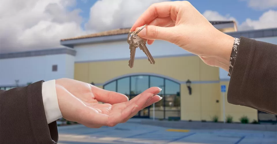 Agent Handing Over the Keys in Front of Business establishment