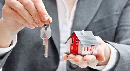 Businesswoman with house model and keys