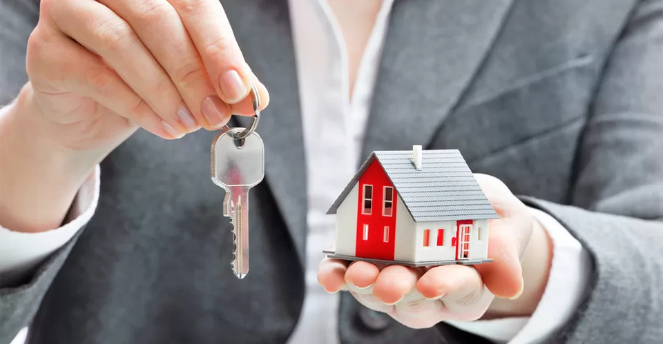 Businesswoman with house model and keys