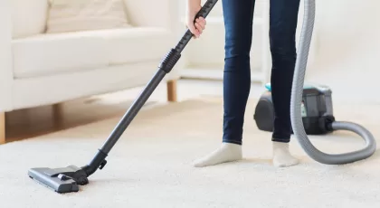 Close up of woman legs with vacuum cleaner