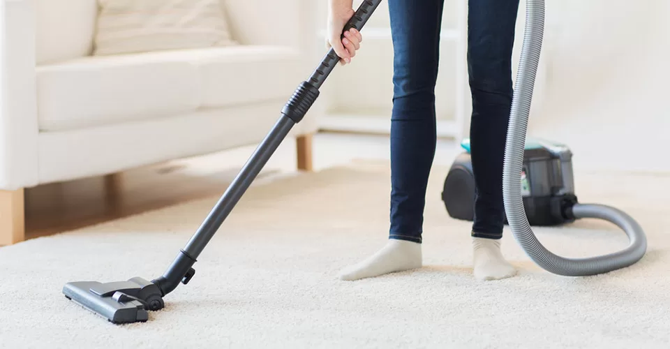 Close up of woman legs with vacuum cleaner