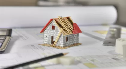 Construction plans with drawing tools and House Miniature on bluprint