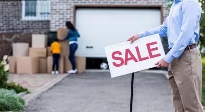 Realtor with sale signboard