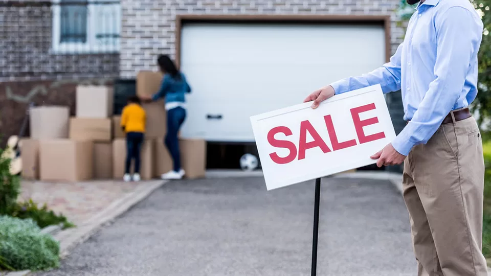 Realtor with sale signboard