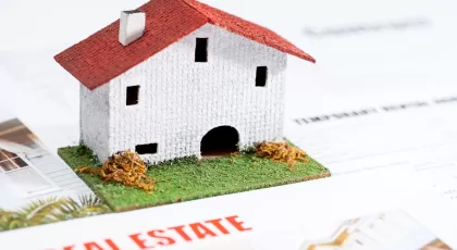 Small toy house on real estate documents
