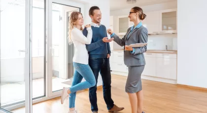 a man and a woman getting the keys to their new home