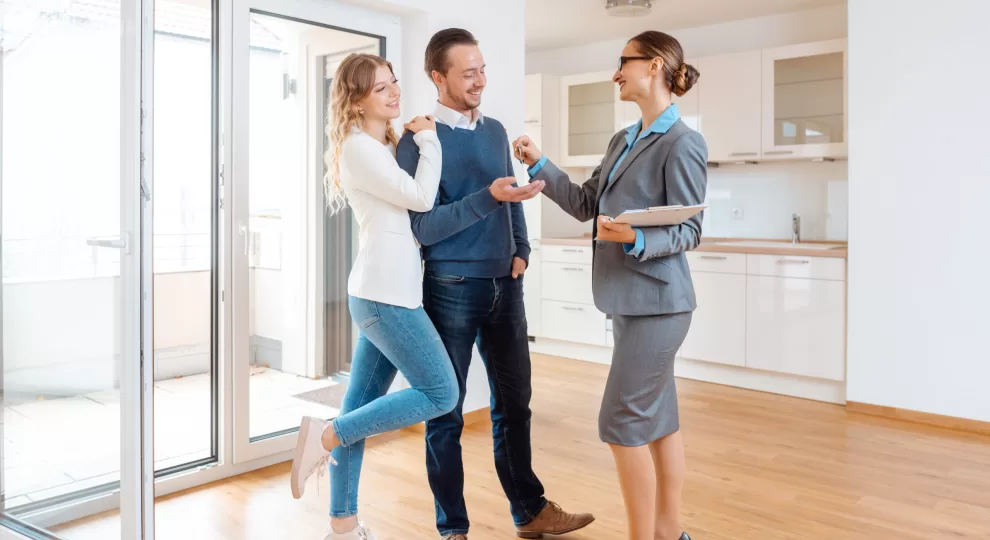 a man and a woman getting the keys to their new home