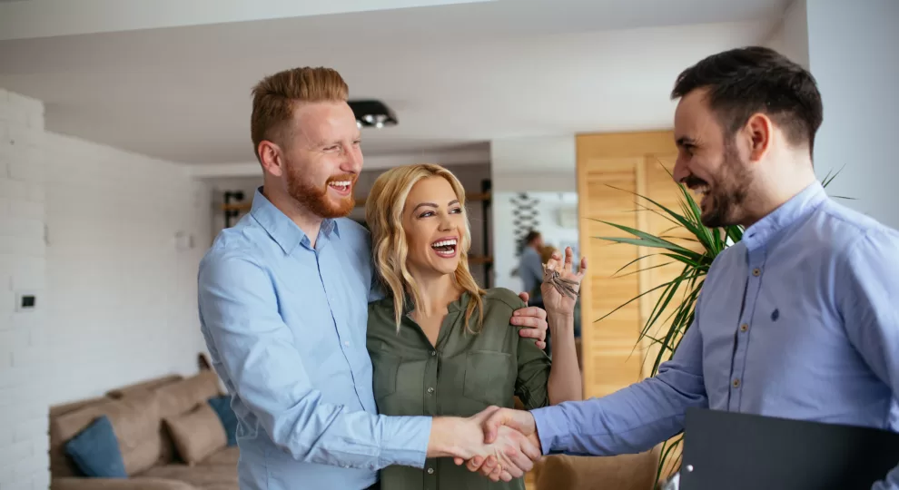 a man and a woman happily getting the keys from an agent