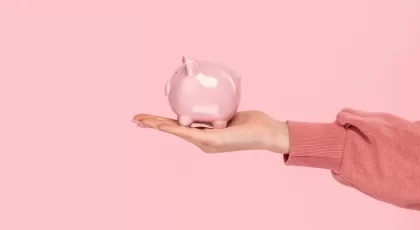 a hand holding a pink ceramic pig