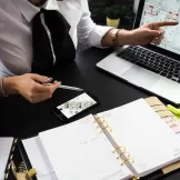 a woman pointing to a floorplan on her laptop's screen