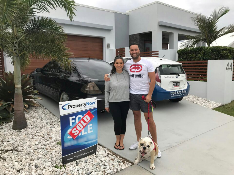 Selling a House - For Sale By Owner 3 a woman and a man with their dog standing next to a PropertyNow for sale sign with the word 'SOLD' added to it