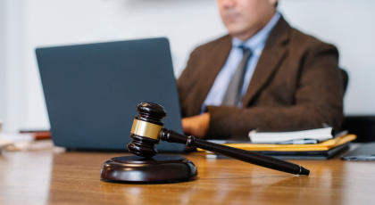 Auction vs private treaty — an auction gavel beside a for-sale sign, weighing up two ways to sell