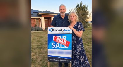 Sharon and Lindsay holding a PropertyNow for sale sign marked sold, in front of the Hodgson Vale home they sold privately